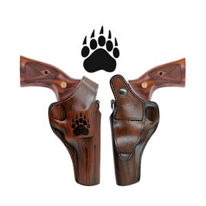 May include: Two brown leather holsters with a bear paw design. The holsters are designed to fit a revolver.