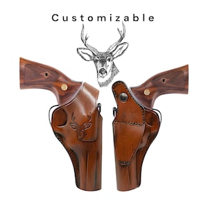May include: Two brown leather gun holsters with a deer head design, paired with two revolvers with wooden handles. The word "Customizable" is printed above the holsters. The holsters are designed to fit the revolvers.
