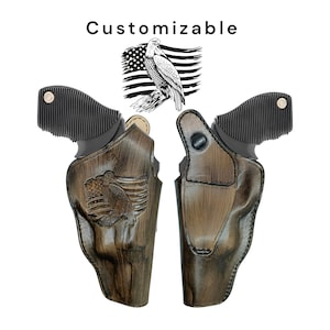May include: Two brown leather gun holsters with an eagle and American flag design. The holsters have a distressed finish. The word "Customizable" is above the holsters. The holsters are shown against a white background.