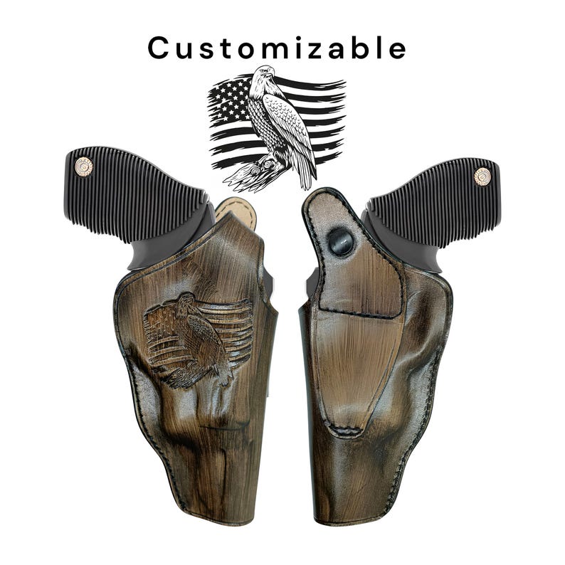 May include: Two brown leather gun holsters with an eagle and American flag design. The holsters have a distressed finish. The word "Customizable" is above the holsters. The holsters are shown against a white background.