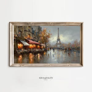 May include: A framed print of a Parisian street scene. The artwork depicts a rainy day with a cafe, people, and the Eiffel Tower in the background. The color palette includes warm tones from the cafe lights and cooler tones for the sky and wet pavement.
