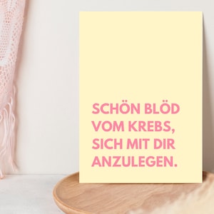 May include: A yellow poster with pink text that reads "Sch&ouml;n bl&ouml;d vom Krebs, sich mit dir anzulegen."
