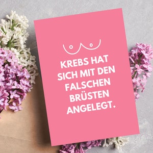 Pode incluir: Cart&atilde;o rosa com um contorno branco de um seio e o texto "Krebs hat sich mit den falschen Br&uuml;sten angelegt."