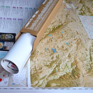 May include: A rolled up map of the United States in a cardboard tube. The map is labeled "Landforms of the United States" and "Segment 11 - 13 - 1980 - 2002".