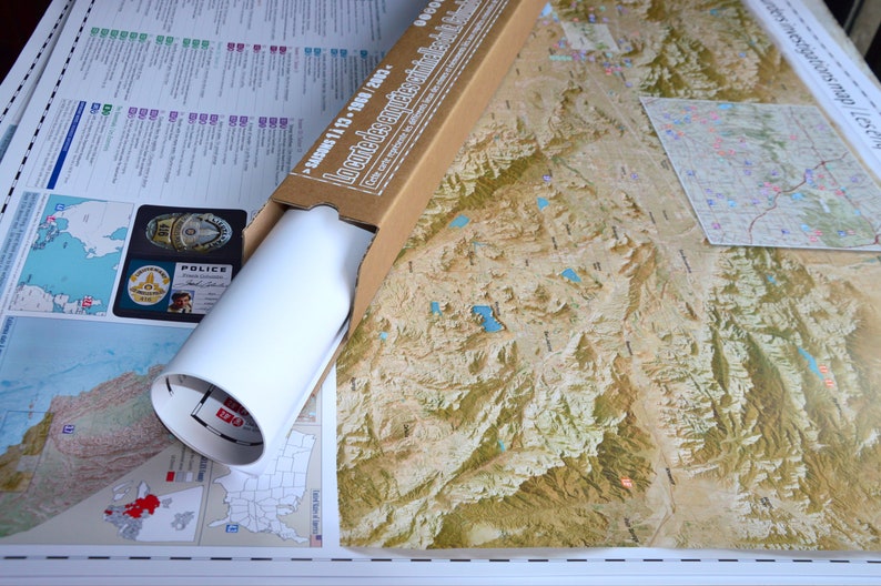 May include: A rolled up map of the United States in a cardboard tube. The map is labeled "Landforms of the United States" and "Segment 11 - 13 - 1980 - 2002".
