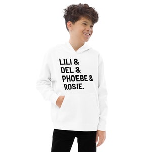 以下が含まれることがあります： 黒い文字で「LILI & DEL & PHOEBE & ROSIE.」と書かれた白いフード付きスウェットシャツ