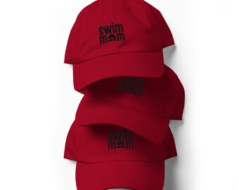 May include: A stack of three red baseball caps, each featuring the black embroidered text "swim mom" with a small icon of swimming goggles positioned between the two words on the front center of the crown.