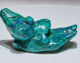 May include: A large, green and blue malachite stone with a unique, organic shape. The stone has a smooth, polished surface and a variety of textures.