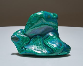 May include: A large, green, and blue malachite stone with swirling patterns. The stone has a smooth, polished surface.