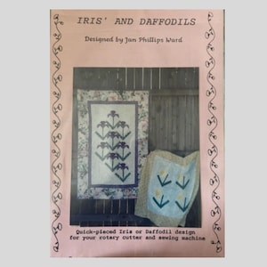 May include: A pink book cover with the title "IRIS' AND DAFFODILS" and the designer's name. The image shows two quilts with floral designs. The text below reads "Quick-pieced Iris or Daffodil design for your rotary cutter and sewing machine."