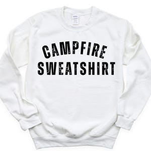 May include: A white sweatshirt with the words "CAMPFIRE SWEATSHIRT" printed in bold, black letters across the front. The sweatshirt has long sleeves and a crew neck.