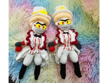 Puede incluir: Dos juguetes de peluche de crochet blanco con trajes a rayas rojas y blancas, botas negras y sombreros amarillos. Los juguetes tienen trajes a rayas rojas y blancas, botas negras y sombreros amarillos. Los juguetes tienen ojos negros con pupilas rojas y una amplia sonrisa de dientes.
