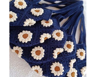 May include: A set of crocheted tote bags featuring daisy flower designs. The bags are navy blue with white and brown daisy flowers.