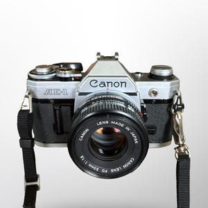 Cámara de película Canon AE-1 de 35 mm vintage, objetivo Canon de 50 mm f/1.8, revisada y probada, batería y rollo de película incluidos, lista para usar.