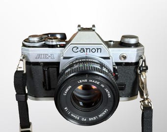 Zabytkowy aparat fotograficzny Canon AE-1 35 mm, obiektyw Canon 50 mm 1:1.8, serwisowany i testowany, w zestawie bateria i rolka filmu, gotowy do fotografowania