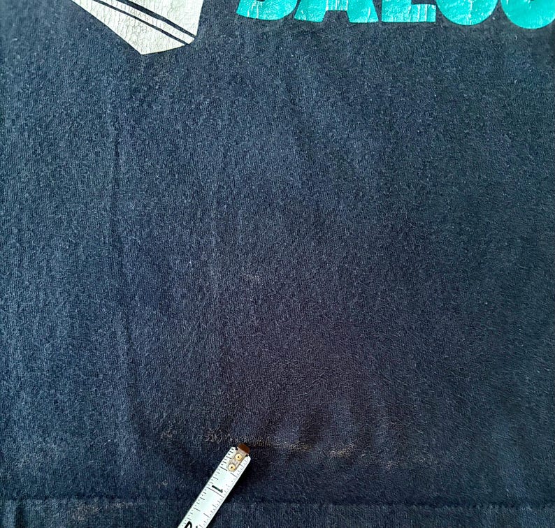 May include: A black t-shirt with a faded teal graphic that says "SALOON".