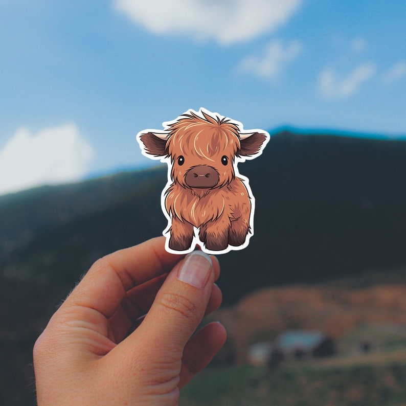 Photo of a baby highland cow sticker. Very cute baby animal. With several tones of brown.