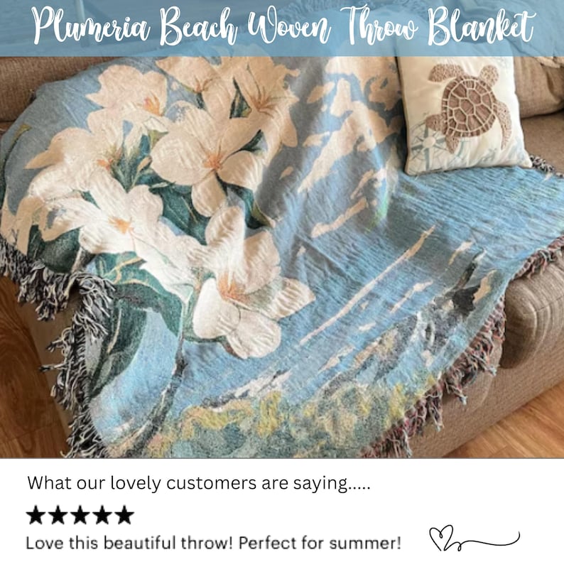 May include: A woven throw blanket with a blue background and large white plumeria flowers. The blanket has a fringed edge and the text "Plumeria Beach Woven Throw Blanket" is at the top. A pillow with a turtle design is also visible.