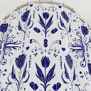 May include: A white shower curtain with a blue floral pattern featuring tulips and hearts. The pattern is repeated throughout the curtain.