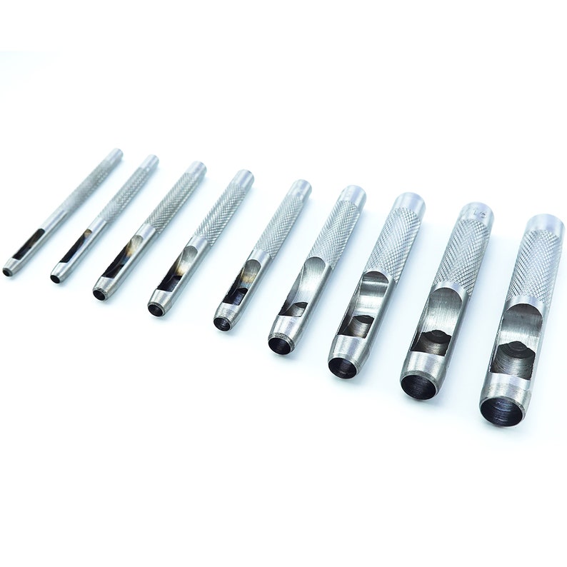 May include: A set of ten silver metal leather hole punch tools of varying sizes. The tools are arranged in a row from largest to smallest.