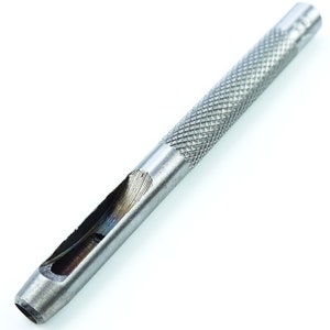 May include: A silver metal leather punch tool with a textured handle.
