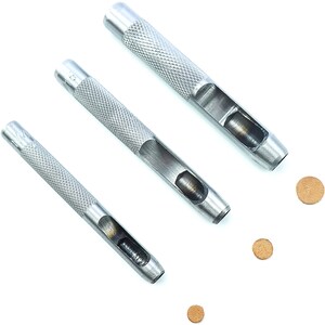 May include: Three silver leather hole punch tools with different sized holes. Three brown leather circles are also shown.