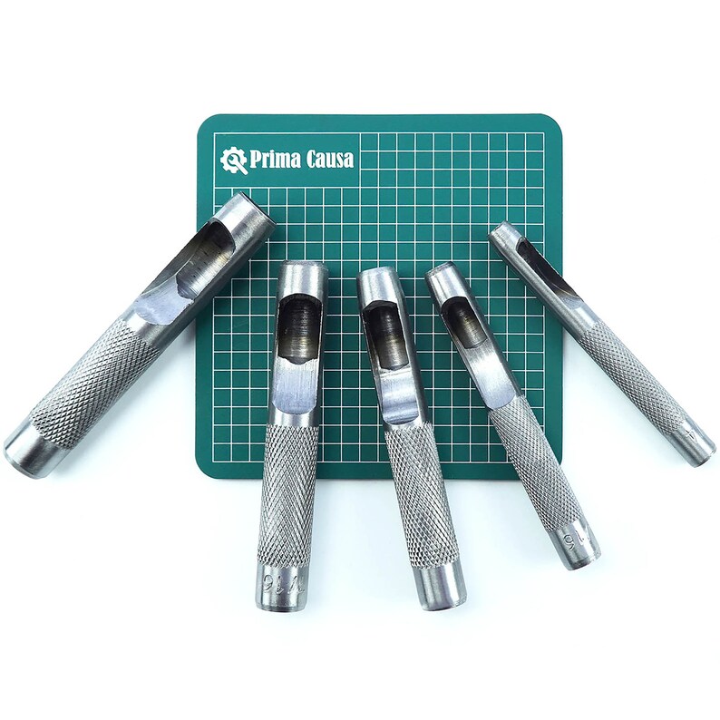 May include: Set of six silver metal leather hole punches on a green cutting mat. The punches are different sizes and have a textured grip.