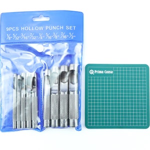 May include: A set of nine hollow punches in a clear plastic bag with a blue header that reads "9PCS HOLLOW PUNCH SET 1/8" 5/32" 3/16" 7/32" 1/4" 5/16" 7/16" 1/2" ". The punches are arranged in order of size, with the smallest punch on the left and the largest punch on the right. A green cutting mat with the text "Prima Causa" is to the right of the punches.
