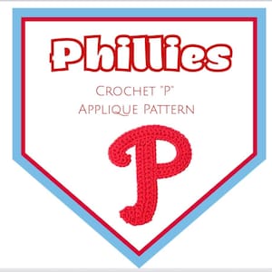 May include: A red crochet letter "P" applique pattern, set against a white background within a blue and red pennant shape. The word "Phillies" is displayed above the pattern, with the text "CROCHET 'P' APPLIQUE PATTERN" below.