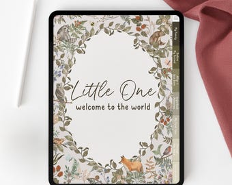 May include: A digital tablet displaying a baby journal design. The journal features a floral border with woodland creatures and the text "Little One welcome to the world". A white stylus and a pink fabric are on the white surface.