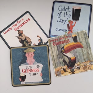 Puede incluir: Cuatro posavasos cuadrados con diferentes ilustraciones y el texto "GUINNESS". Los posavasos son azules, blancos y marrones con im&aacute;genes de un oso, un tuc&aacute;n, un hombre sosteniendo un peri&oacute;dico y un hombre sosteniendo un vaso de cerveza.