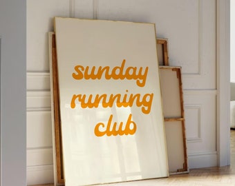 May include: A white framed poster with the text "sunday running club" in orange lettering.