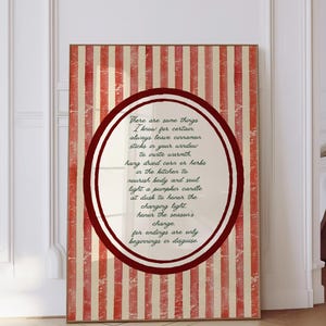 May include: A framed print with a red and cream striped background. A circular design in the center features a quote in a handwritten style. The quote is about creating warmth and honoring the seasons.