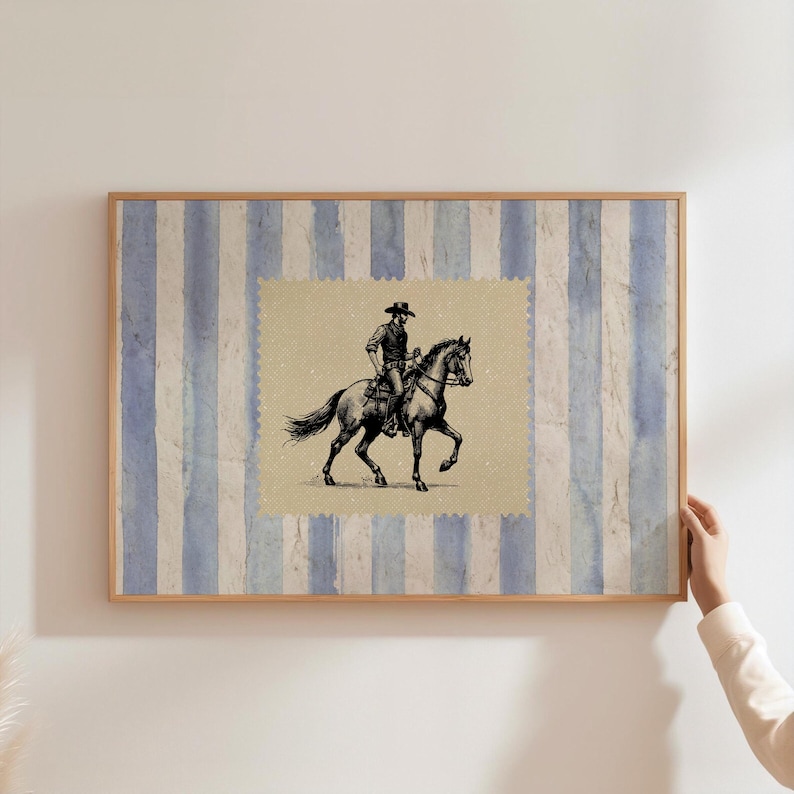 Pu&ograve; includere: Una stampa incorniciata con uno sfondo a strisce blu e bianche. La stampa presenta un'illustrazione in bianco e nero di un cowboy a cavallo.