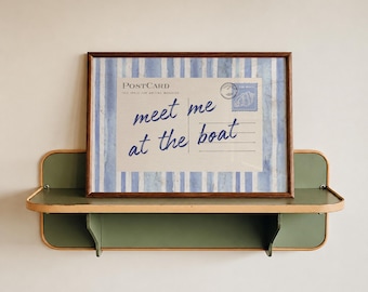 May include: A rectangular framed print featuring a postcard design with blue and white vertical stripes. The text reads POSTCARD and meet me at the boat in blue script, accompanied by a small circular stamp and a blue postage stamp graphic.