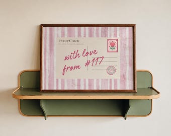 May include: A framed print featuring a postcard design with pink and white vertical stripes. The postcard text reads "POSTCARD" and "with love from #117" in pink script. A red rose stamp and a circular postmark are visible on the right side.