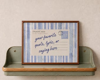 May include: A rectangular framed print featuring a postcard design with blue and white vertical stripes. The postcard includes the text "POSTCARD" and "your favorite quote, lyric, or saying here" in blue script, plus a small stamp graphic.
