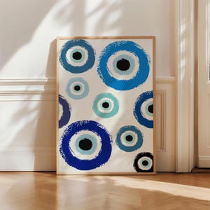 May include: A white background with a pattern of blue and white evil eye designs. The evil eyes are painted in a brushstroke style.