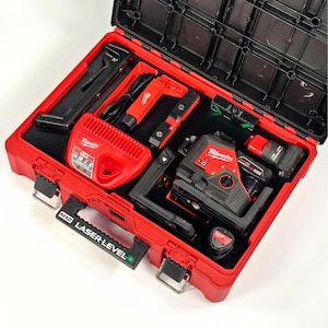 May include: A red and black Milwaukee M12 laser level kit in a red hard case. The case contains a laser level, charger, and other tools. The handle reads "M12 Laser Level".