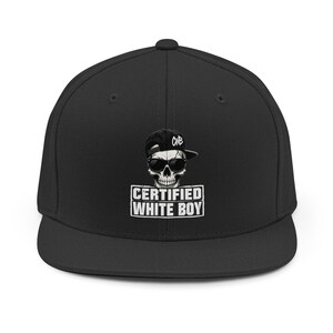 Peut inclure: Une casquette de baseball noire arborant un motif de crâne portant des lunettes de soleil et une casquette noire avec les lettres CWB. Sous le crâne, le texte CERTIFIED WHITE BOY est imprimé en lettres blanches grasses dans un bloc rectangulaire.