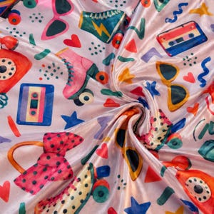 May include: A light pink fabric featuring a repeating pattern of 1980s-themed illustrations including cassette tapes, roller skates, rotary telephones, sunglasses, polka-dot bows, hearts, stars, and geometric shapes in vibrant colours.