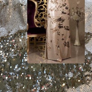 May include: A gold sequined fabric with a shimmering, iridescent finish. The fabric is made of small, round sequins that are sewn together in a close pattern. The sequins are arranged in a wave-like pattern, creating a textured and luxurious look.
