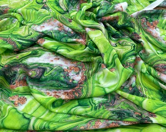 May include: Green fabric with a marbled pattern in shades of green, white, and gold. The fabric has a soft, flowing texture.