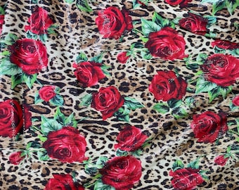 May include: Red roses with green leaves on a brown and beige leopard print fabric.