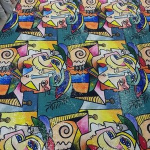 Puede incluir: Una tela colorida con un patrón repetitivo de caras abstractas en estilo cubista. La tela está hecha de lentejuelas y tiene un acabado brillante.