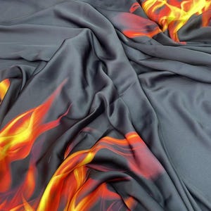 Puede incluir: Tela gris oscuro con un vibrante diseño de llamas en tonos rojos, naranjas y amarillos. La tela está drapeada, mostrando el diseño fluido y las variaciones de color. Ideal para ropa o decoración del hogar.