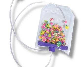 May include: A clear plastic pouch filled with colorful fruit-shaped polymer clay slices. The pouch has a purple base and a clear tube extending to a white earbud. The fruit shapes include watermelon, strawberries, and citrus fruits.