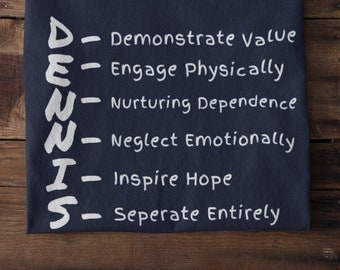 May include: A navy blue t-shirt with white text that reads "DEUUTS" and an acronym for "Demonstrate Value, Engage Physically, Nurturing Dependence, Neglect Emotionally, Inspire Hope, Seperate Entirely".