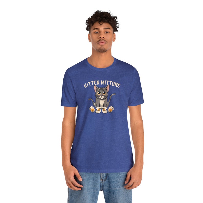 May include: A blue heather t-shirt featuring a cartoon cat wearing mittens and the text "Kitten Mittons".