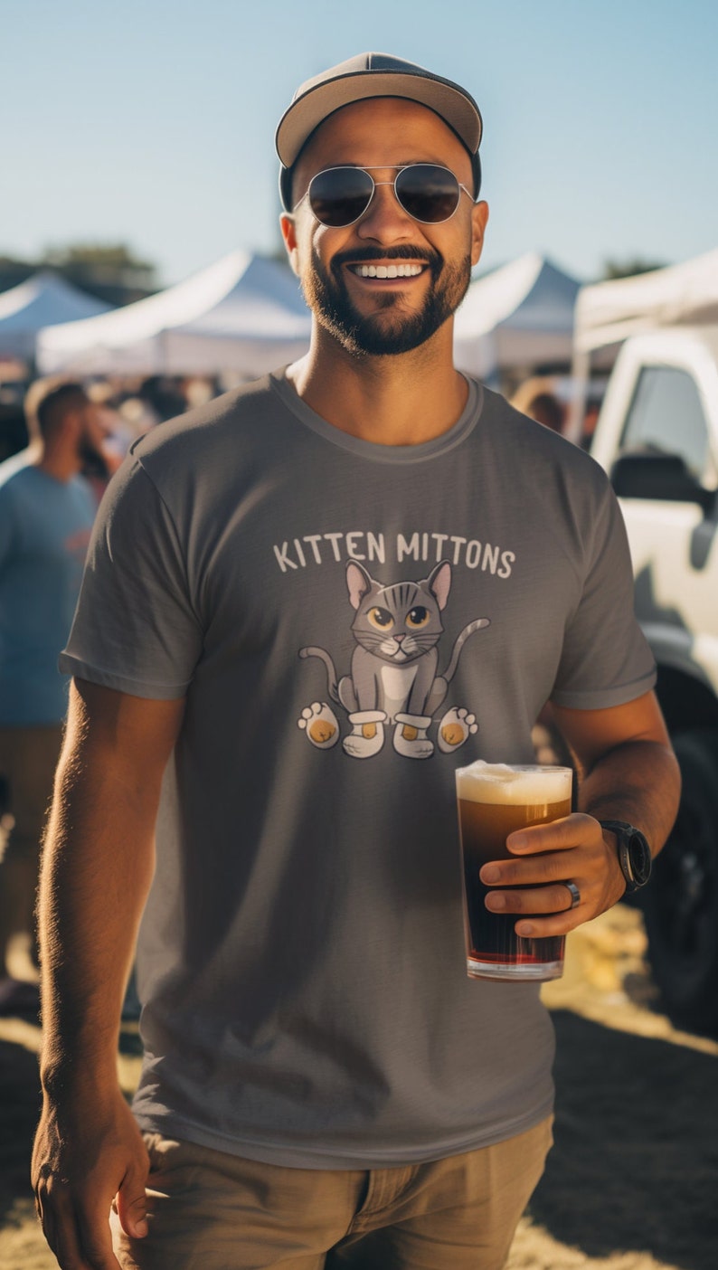 May include: A grey t-shirt featuring a cartoon cat wearing mittens and the text "Kitten Mittons".